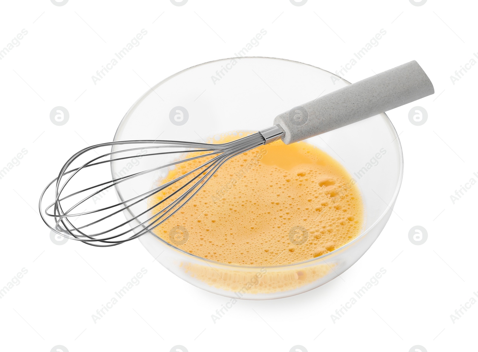 Photo of Beaten eggs in glass bowl and whisk isolated on white