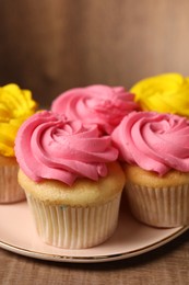 Photo of Delicious cupcakes with bright cream on table, closeup