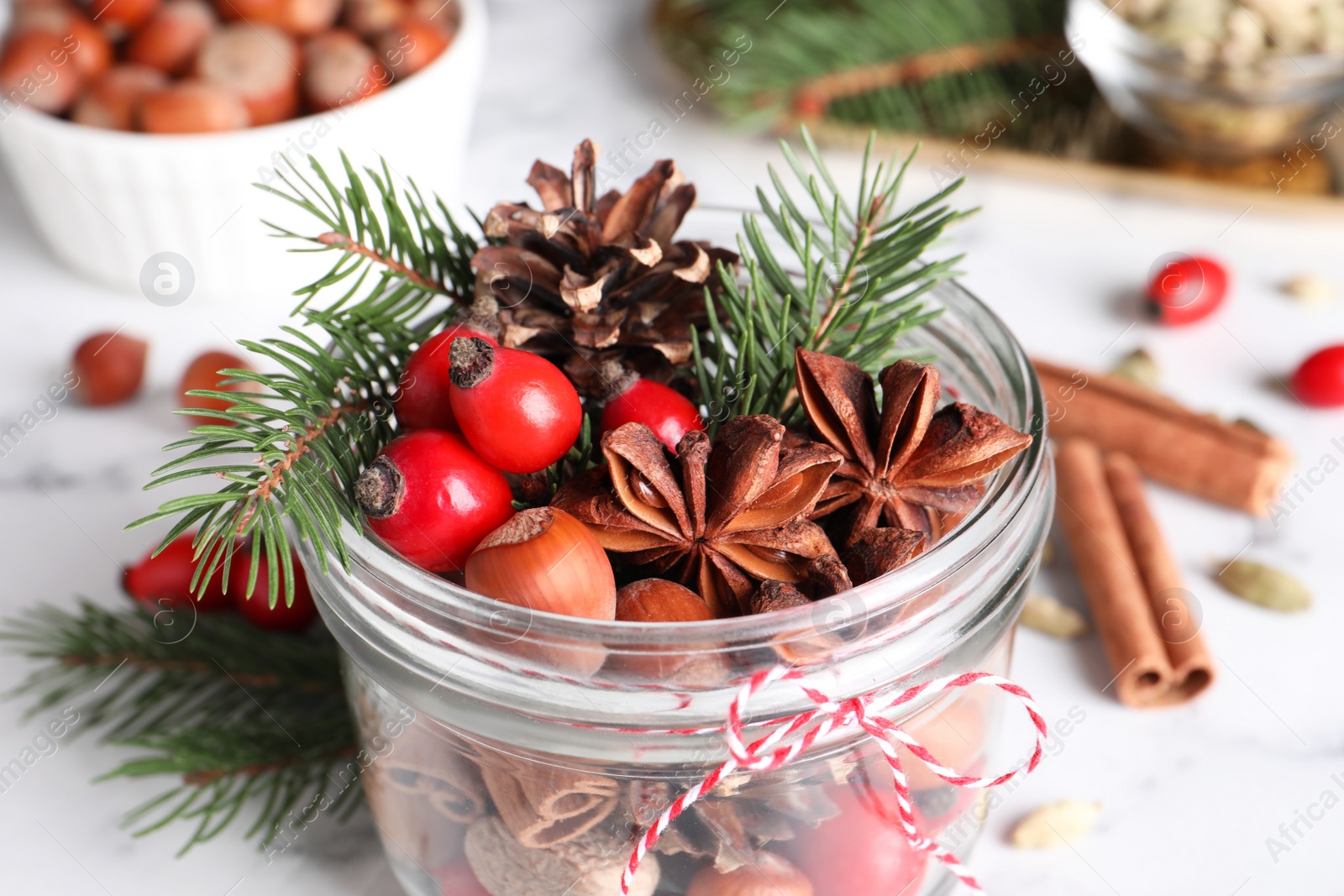 Photo of Aromatic potpourri in glass jar on white table, closeup