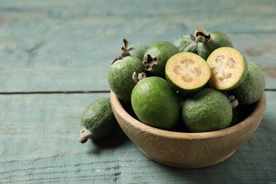 Photo of Fresh green feijoa fruits on blue wooden table, closeup. Space for text