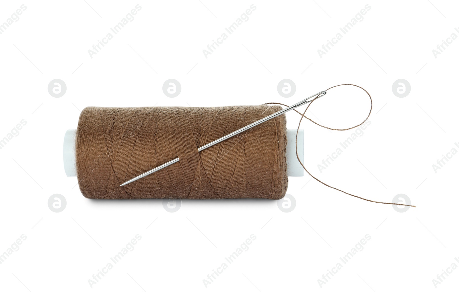 Photo of Spool of brown sewing thread with needle isolated on white