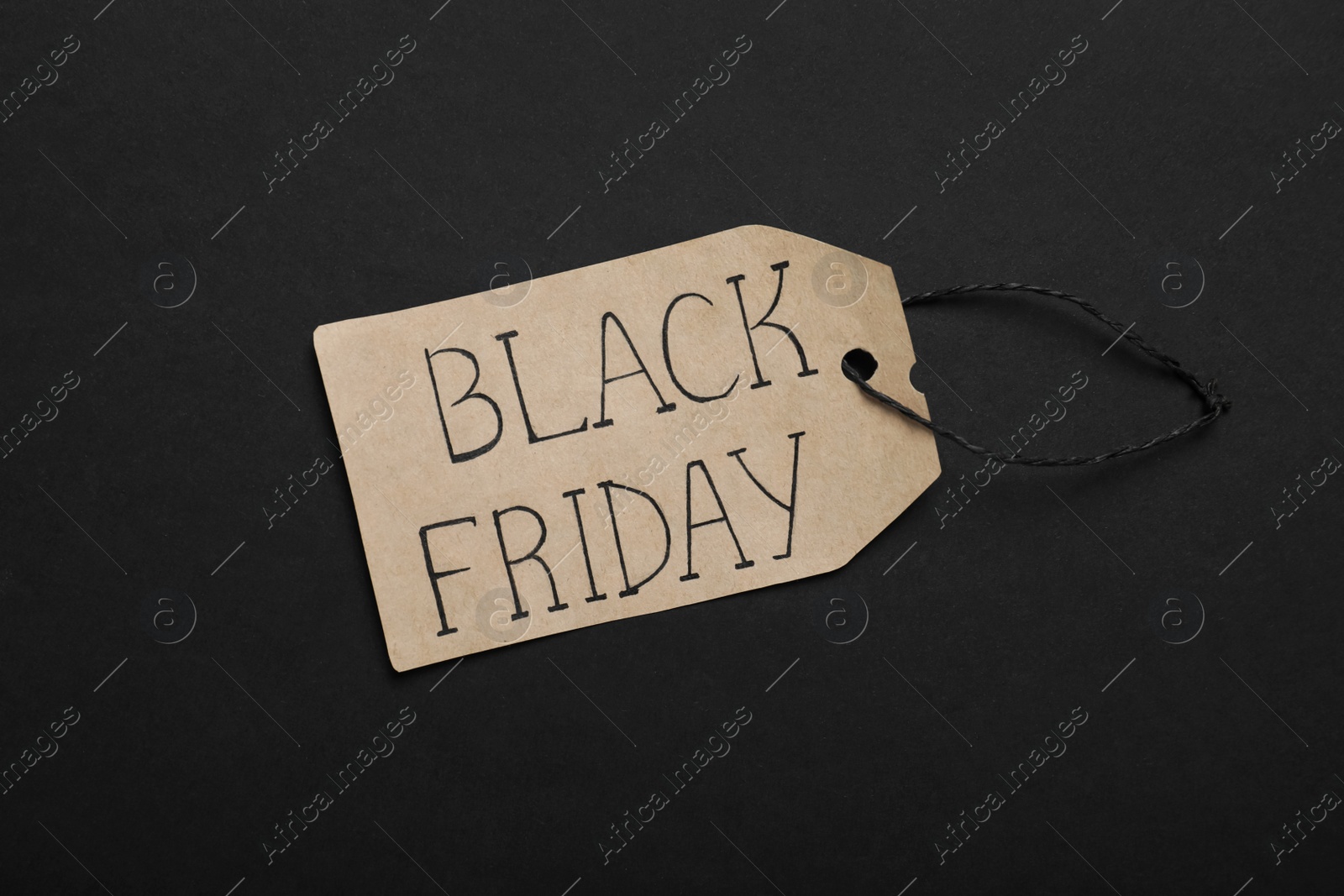 Photo of Black Friday tag on color background, top view