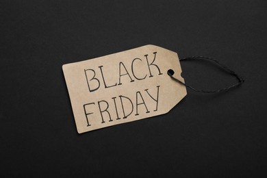 Black Friday tag on color background, top view