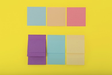 Colorful sticky notes on yellow background, flat lay