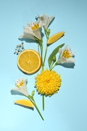Photo of Flat lay composition with alstroemeria flowers and orange slices on light blue background