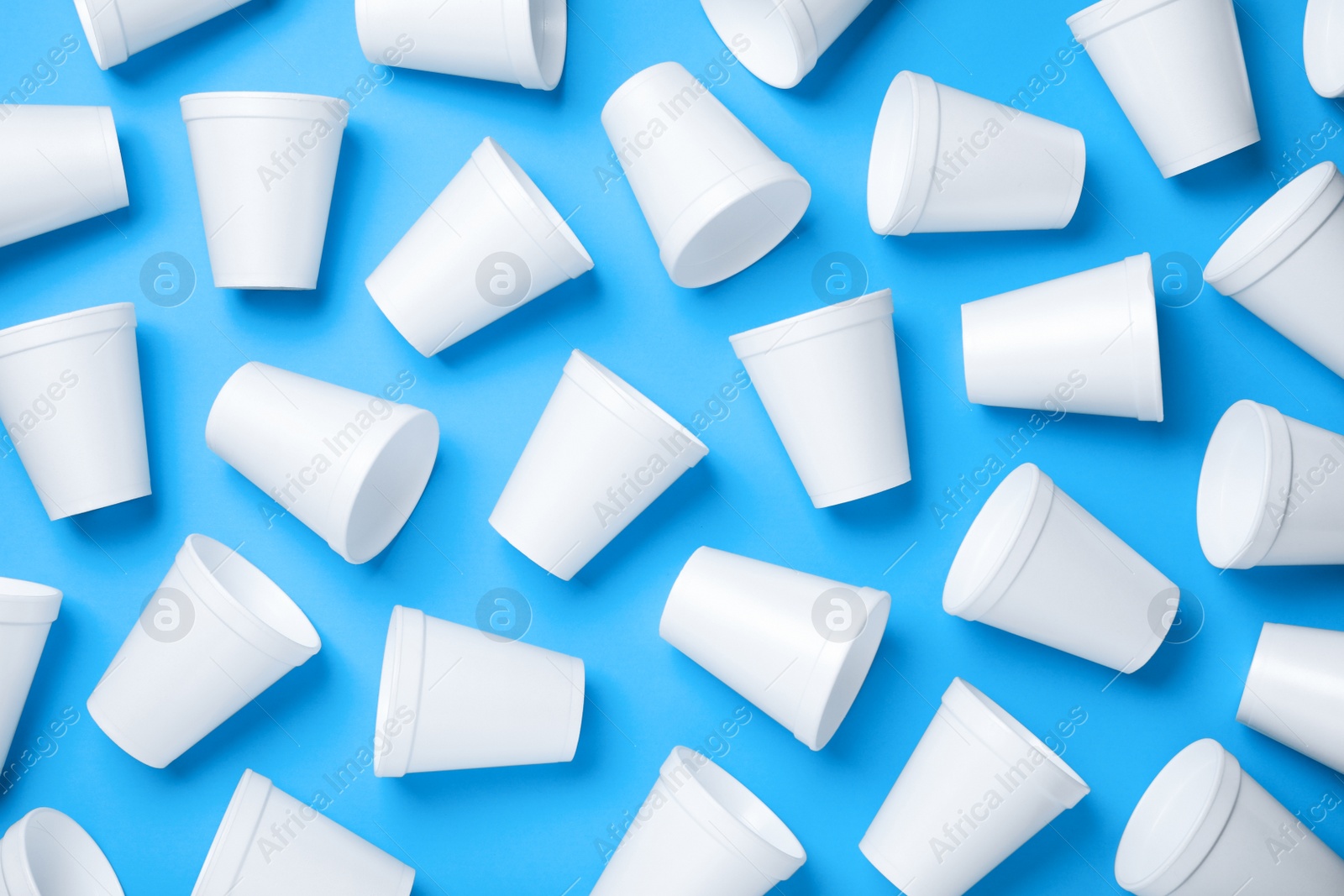 Photo of White styrofoam cups on light blue background, flat lay