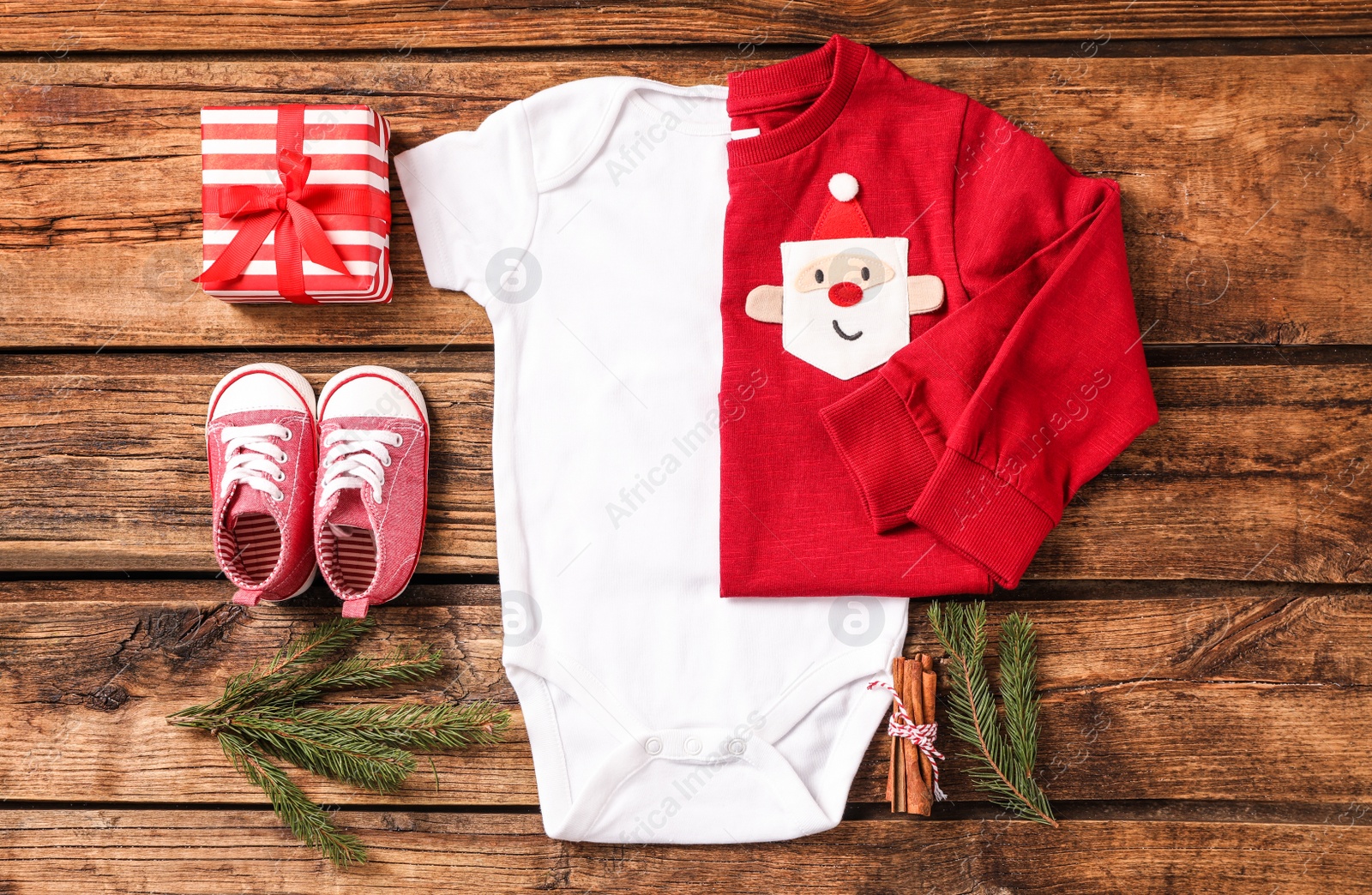 Photo of Flat lay composition with cute Christmas baby clothes on wooden background