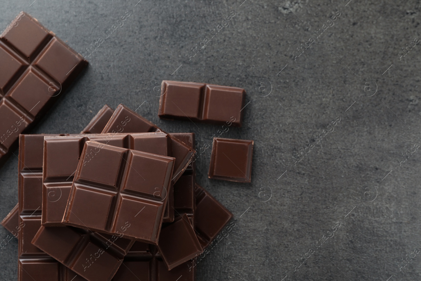 Photo of Delicious dark chocolate on grey table, flat lay. Space for text