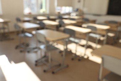 Photo of Blurred viewempty school classroom with desks and chairs