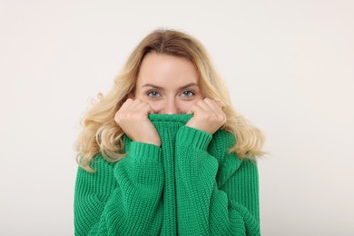 Photo of Beautiful woman in stylish warm sweater on white background