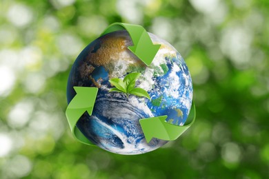 Image of Recycling concept. Earth planet with green arrows and leaves on blurred background, illustration