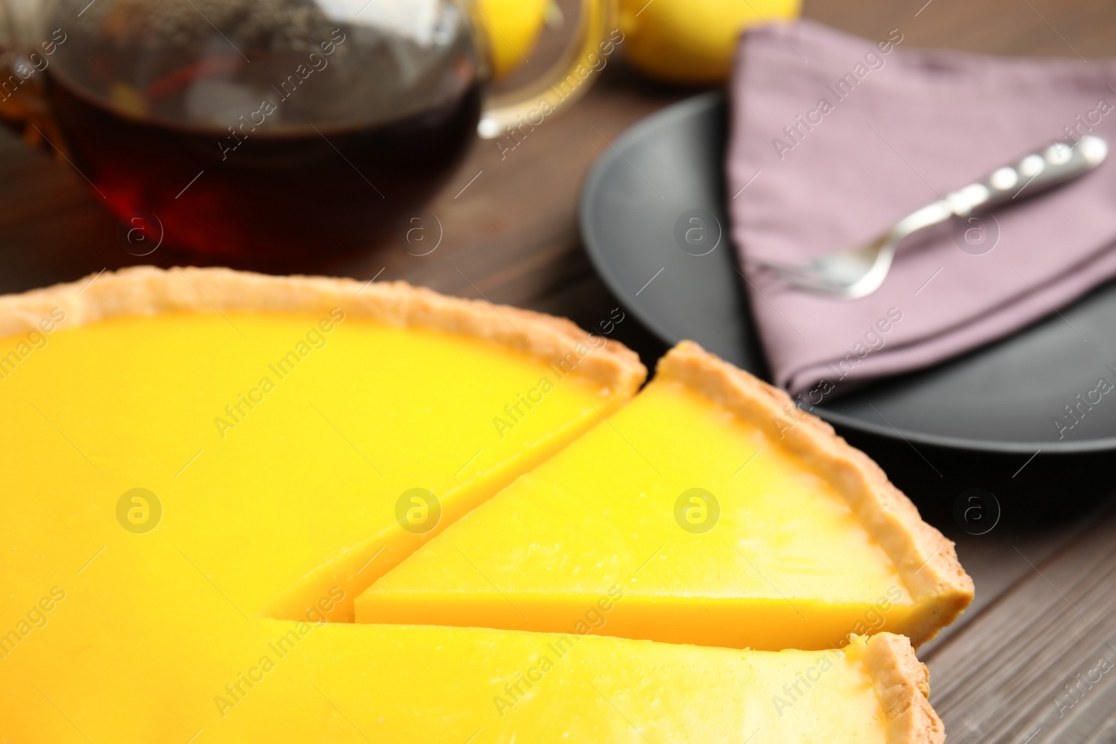 Photo of Delicious homemade lemon pie on wooden table, closeup