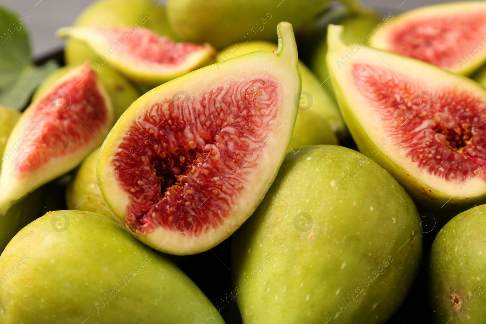 Photo of Cut and whole green figs as background, closeup