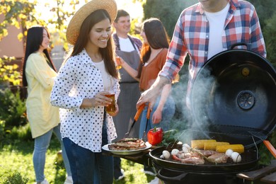 Photo of People with drinks having barbecue party outdoors