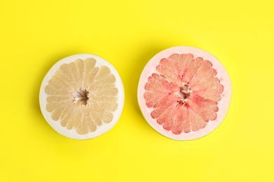 Photo of Fresh cut pomelo fruits on yellow background, flat lay