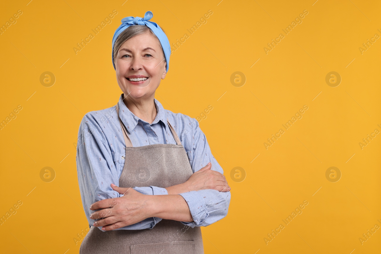 Photo of Happy housewife on orange background, space for text