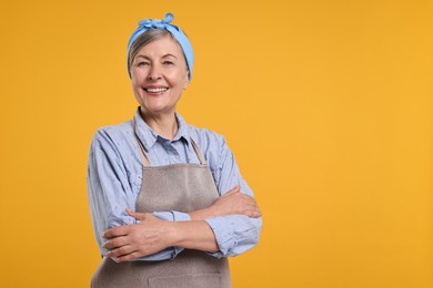 Happy housewife on orange background, space for text