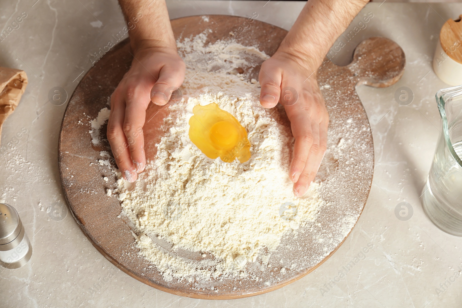 Photo of Man mixing flour and egg on board