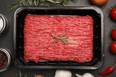 Photo of Raw fresh minced meat and other ingredients on black table, flat lay