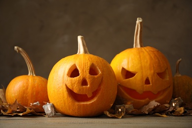 Photo of Composition with pumpkin heads on dark background. Jack lantern - traditional Halloween decor
