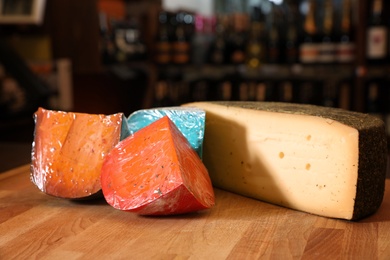 Different types of delicious cheeses on counter in store