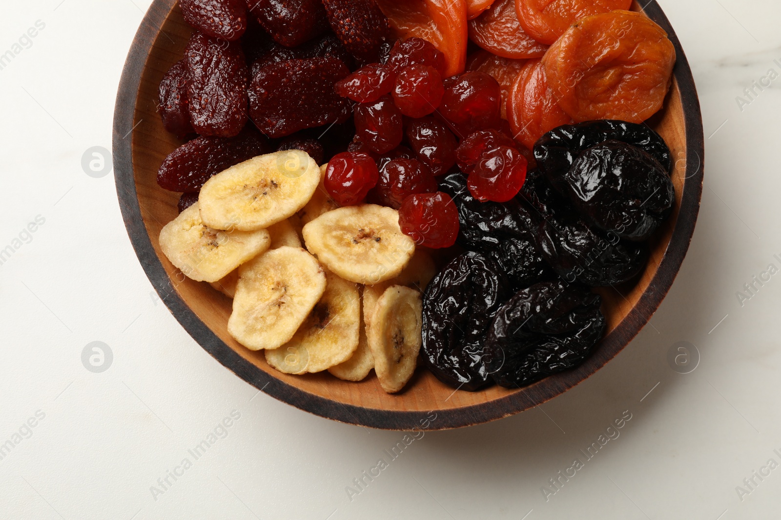 Photo of Mix of delicious dried fruits on white marble table, top view