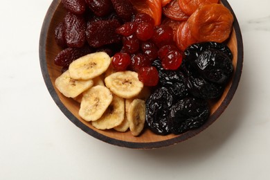 Photo of Mixdelicious dried fruits on white marble table, top view