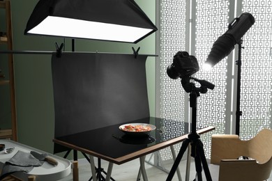 Professional equipment and salad with prosciutto on table in photo studio. Food photography