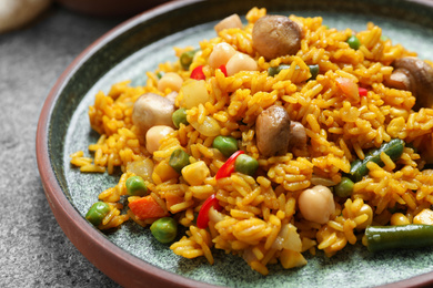 Delicious rice pilaf with vegetables on grey table, closeup