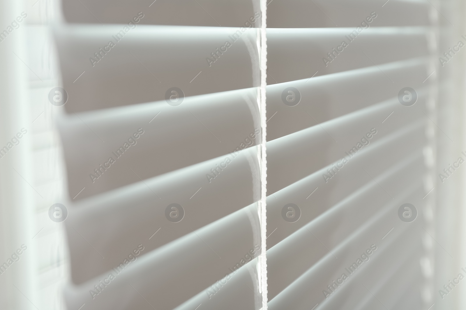 Photo of Closed modern white window blinds, closeup view