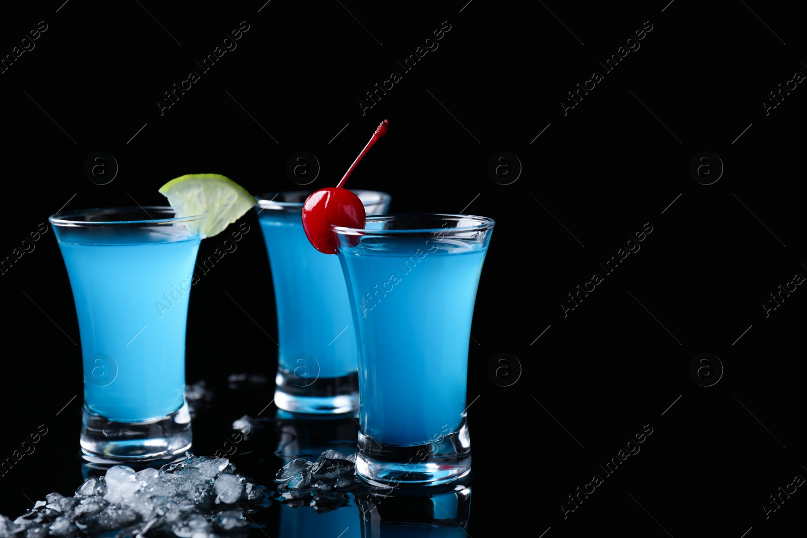 Photo of Bright light blue shots on black table, space for text