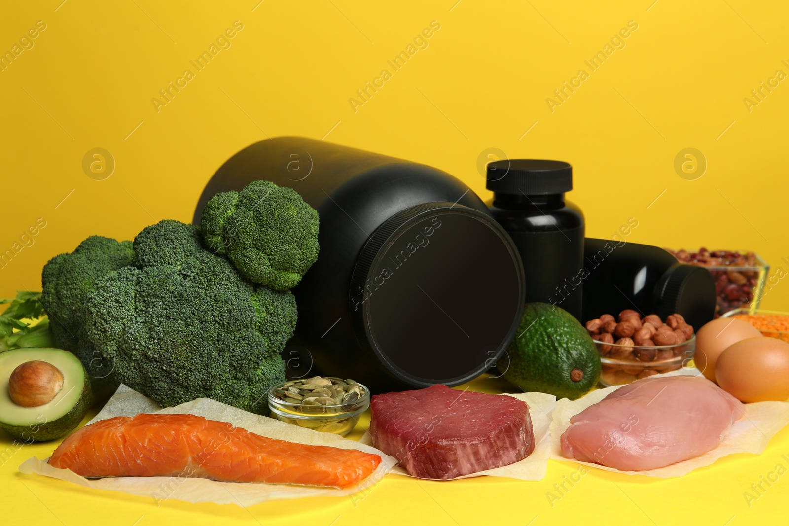 Photo of Set of products rich in amino acids and supplements on yellow background