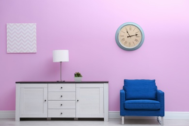 Photo of Room interior with stylish clock on wall. Time of day