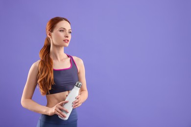 Woman in sportswear with thermo bottle on violet background, space for text