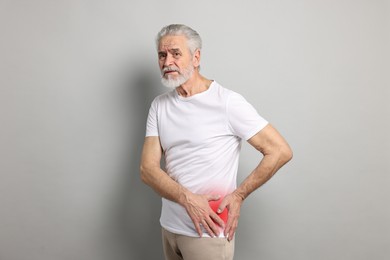 Image of Senior man suffering from pain in hip on grey background