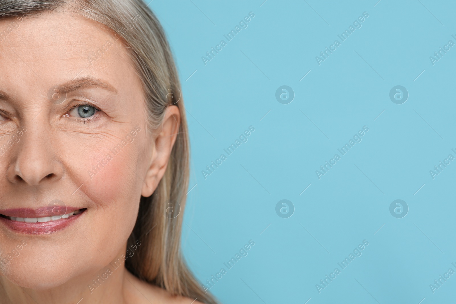 Photo of Senior woman with aging skin on light blue background, closeup and space for text. Rejuvenation treatment