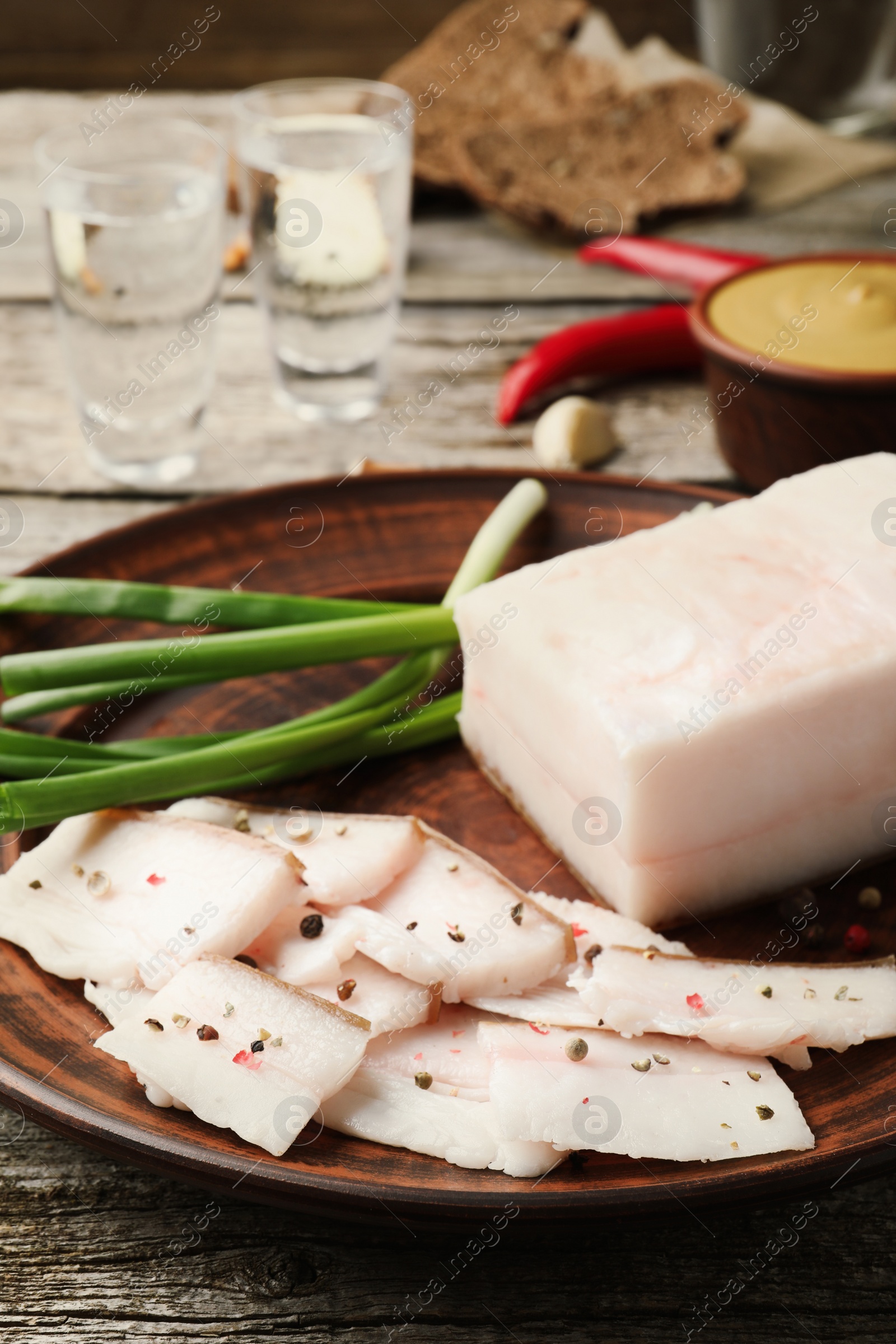 Photo of Tasty salt pork with green onion served on wooden table, closeup