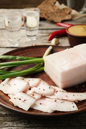 Photo of Tasty salt pork with green onion served on wooden table, closeup