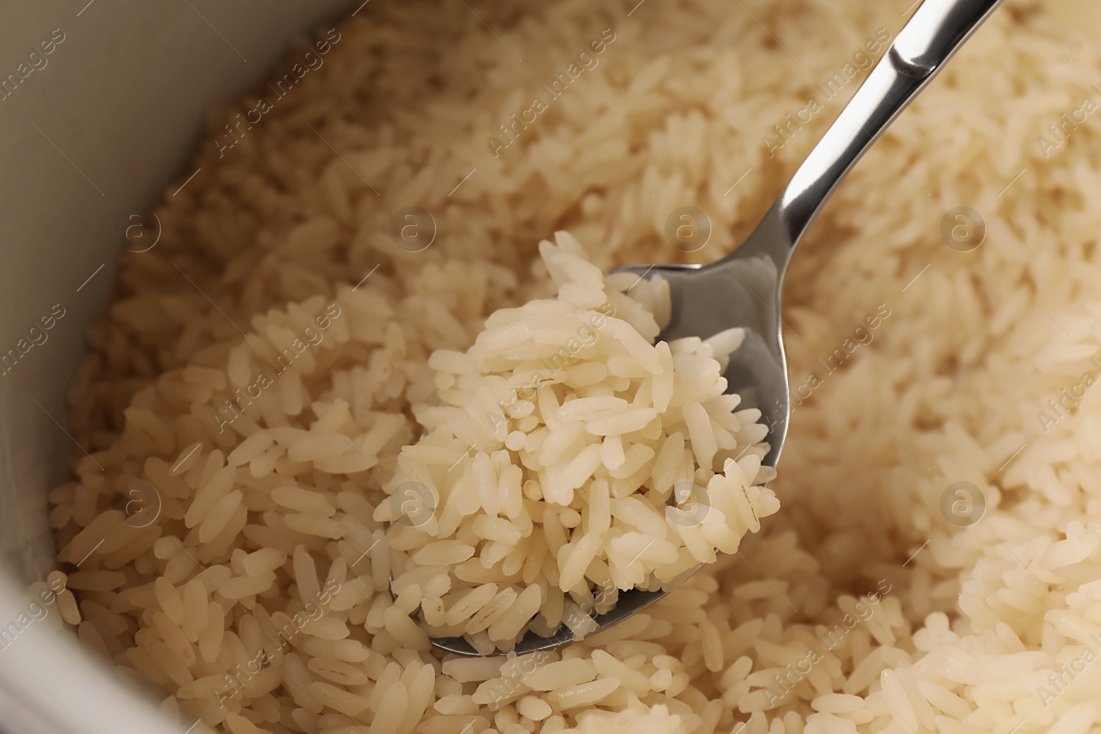 Photo of Pot with delicious rice and spoon, closeup