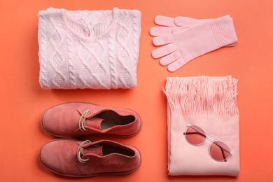 Flat lay composition with warm clothes on coral background