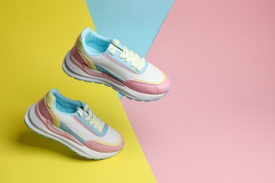 Stylish presentation of bright sneakers on color background, space for text