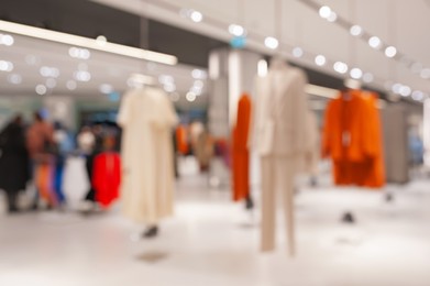 Photo of Blurred view of modern boutique interior with stylish clothes