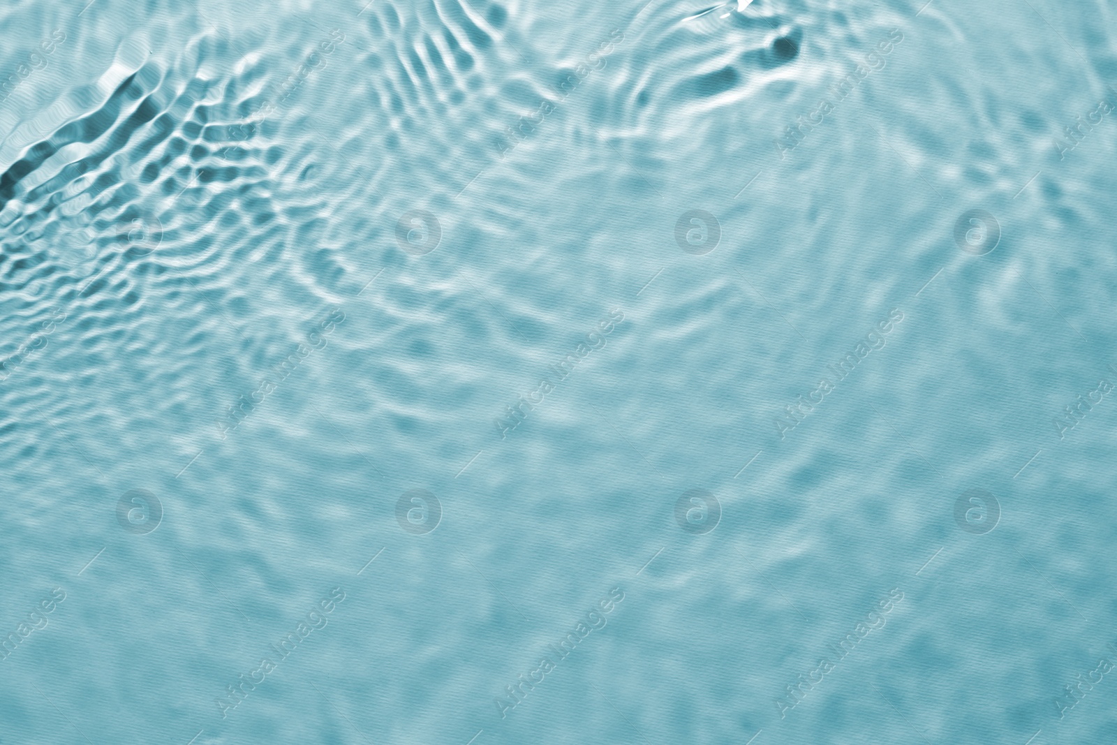 Image of Rippled surface of clear water on light blue background, top view