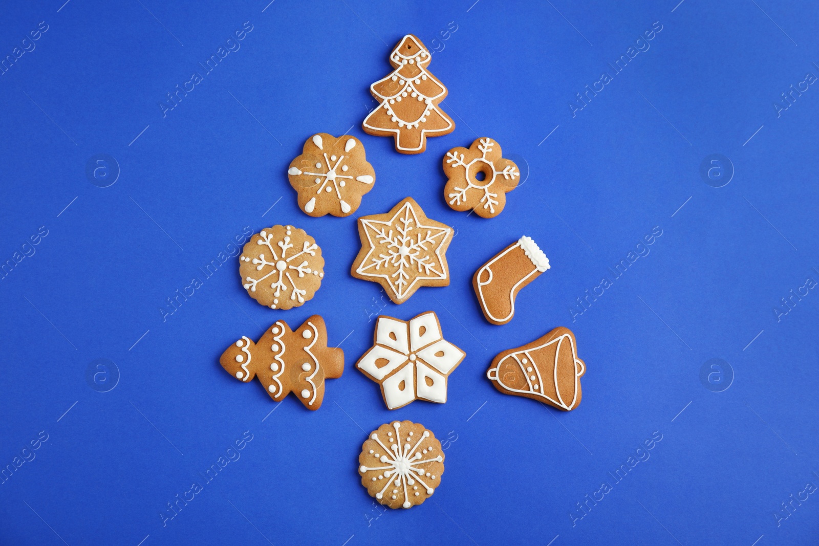 Photo of Christmas tree shape made of tasty homemade cookies on color background, top view