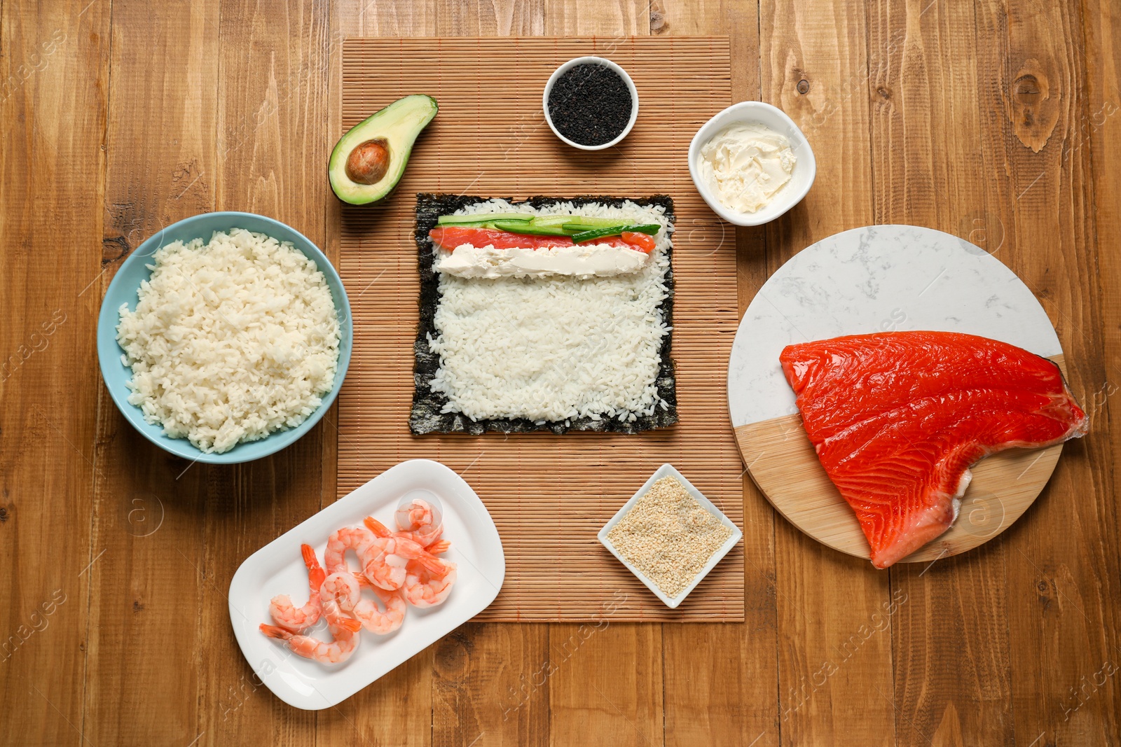 Photo of Flat lay composition with unwrapped sushi roll and products on wooden table