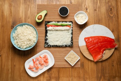 Photo of Flat lay composition with unwrapped sushi roll and products on wooden table