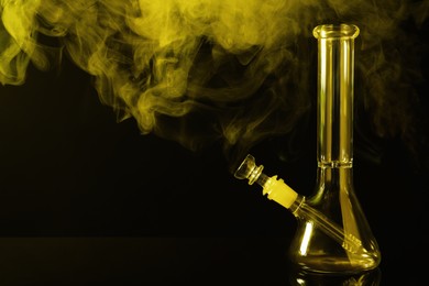 Photo of Glass bong and smoke on black background, space for text. Smoking device
