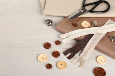 Photo of Composition with different sewing items and fabric on light beige table