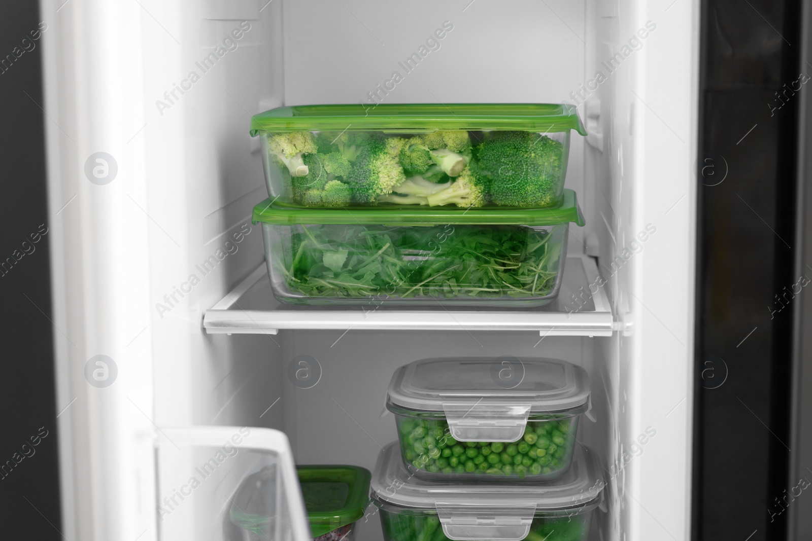 Photo of Glass containers with different fresh products in fridge. Food storage