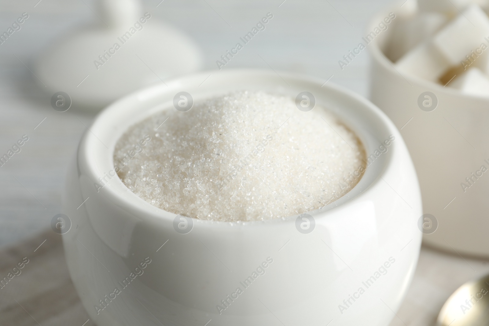 Photo of Ceramic bowl with white sugar, closeup view